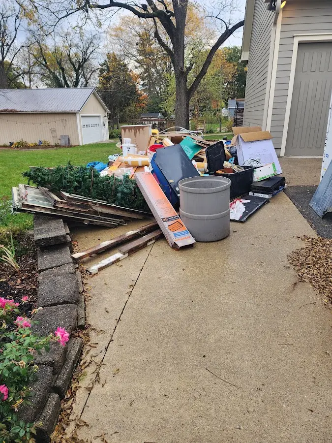 Dumpster being loaded with debris for 12 Yard Dumpster Rental in Hartland